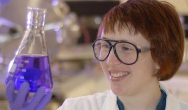 Scientist with liquid in beaker